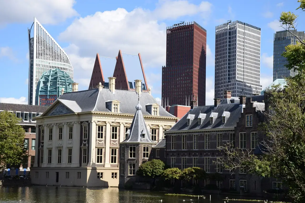 Het Mauritshuis en het Binnenhof aan de Hofvijver, met de skyline van Den Haag